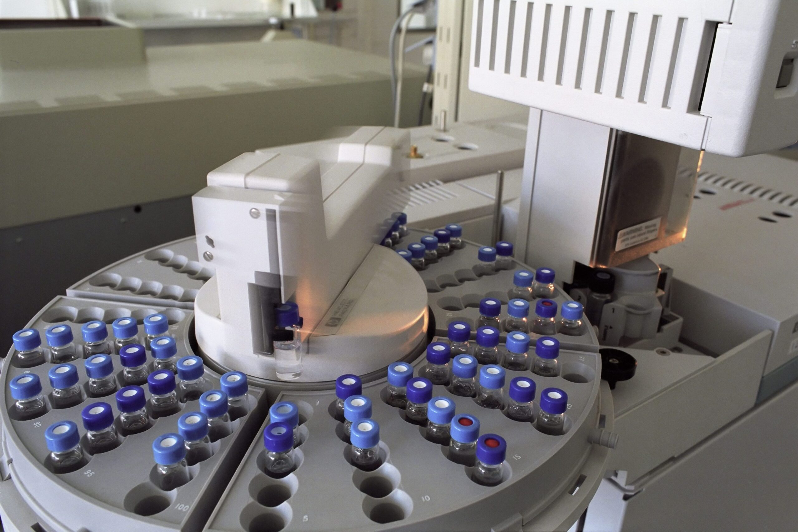 A gas chromatograph autosampler carousel loaded with sealed, crimp-capped sample vials.